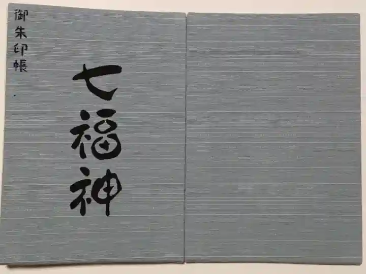 七福神専用の御朱印帳になります。
そのため各頁は見開きで、表側は左に御朱印を記載(または書置きを貼り)左にイラスト、裏側は同じく左に御朱印で右は各神様の説明書きとなっています。
色は4種類、深川鼠、薄藍、砥粉色、若竹色があり、これは深川鼠になります。
実際には写真よりももう少し青みがかっています。
一冊4950円になります。