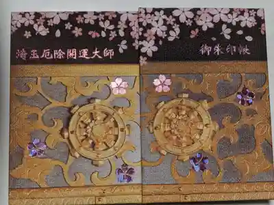御朱印帳も桜の花がホログラムになっていてあちこち傾けて模様の違いを楽しむことができます。最初はこちらの御朱印に切り絵を貼るつもりでしたが、２つに折らないと貼れません。でも折るのはどうしてももったいなくてできません。色々考えて、最終的な結論は額に入れて飾ることでした。