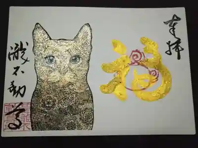 ゴールドラメの猫の御朱印。目はエメラルド。金文字です。