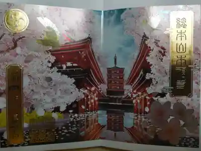 桜箔押し御朱印。五重塔、満開の桜の木、めじろ2羽のイラスト。パールメタリック調の紙に印刷され金の箔押しが施され、手元で動かすとキラキラします。