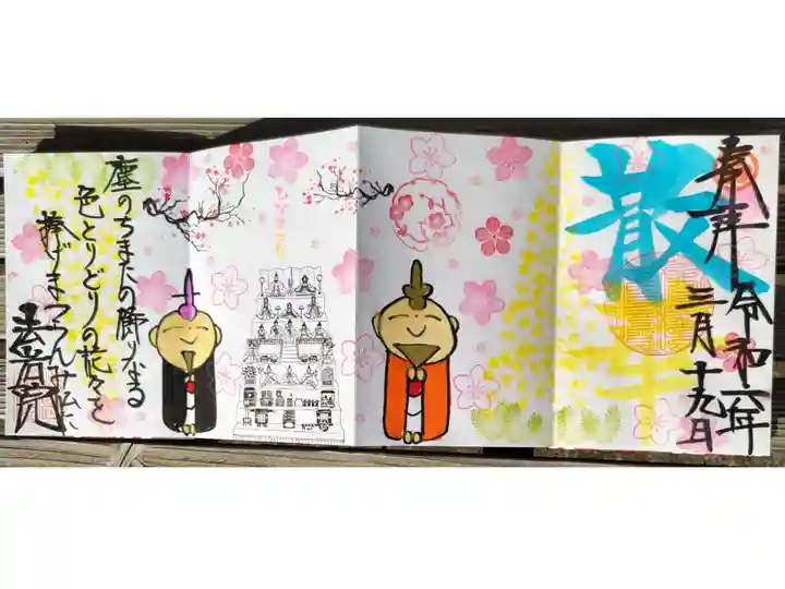 四面見開き御朱印。散華。手描きのお雛様とお内裏様の絵、菜の花畑、ひな人形七段飾り、桜の花、梅の花の絵。塵のちまたの飾りなる色とりどりの花々を捧げまつらんみ仏に。