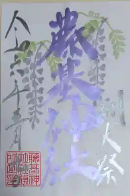 藤基神社令和六年5月例大祭御朱印。藤の花のイラストはんこの絵、パール藤色の文字で藤基神社、銀の文字で例大祭、日付。