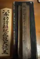 昭和41年に作られた版木。60年を経た今も、龍神祭のお札を生み出しています。
墨ののせ方ひとつで表情が変わる、繊細な仕事。
この木に刻まれた時間と祈りが、今日も一枚のお札になります。
大札は今も願いと祈りを込めて手書きです。