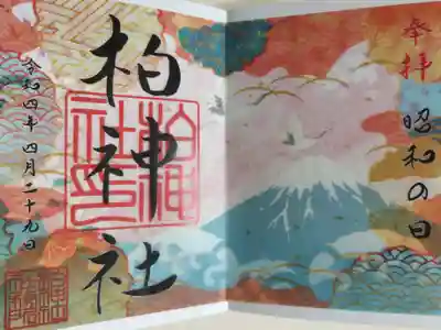 昭和の日。トレーシングペーパーに文字と神印、文様。下の紙に富士山、海の波頭、飛翔する鶴、桜の絵