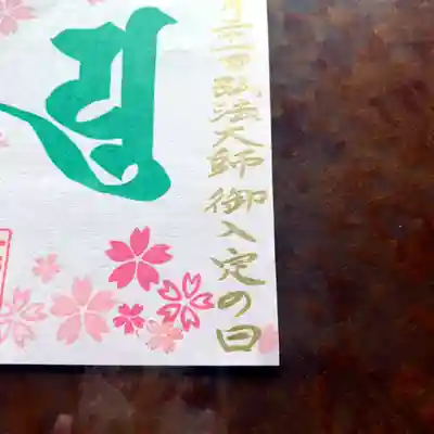 
金文字で書きました「御入定の日」というのは、弘法大師・空海さんが「永遠の瞑想に入られた日」のことですが……要するにこれは、普通の人でいう「ご命日」のことです。
　
空海さんはご自身が宣言した通り、「この世をすべての人を救うために、永遠の禅定（ぜんじょう、瞑想のこと）に入られたのだ」と、彼を慕う多くの人々が今も信じているので、「ご入定」という言い方をします。
　
しかも、たとえば四国遍路では、「空海さんが、遍路をする一人一人に、常に一緒に歩いてくれる」という「同行二人（どうぎょう・ににん）」という考えがあるように、「歴史上の偉人」という枠や物理的な制約を越えた、正真正銘の仏さまのように思っているんですね。
　
ですので、桜を見て華やぐ心にも、友だちみんなでお花見が出来なくて寂しく思う気持ちにも……それ以外のどんな時でも、やっぱり空海さんは私たちの傍にいてくれるんじゃないかなぁと思っています。

